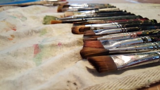 Close-up of various paintbrushes and gloves arranged neatly.