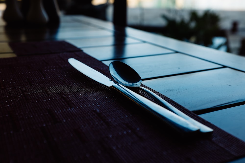 deux cuillères en acier inoxydable à côté du couteau sur la table