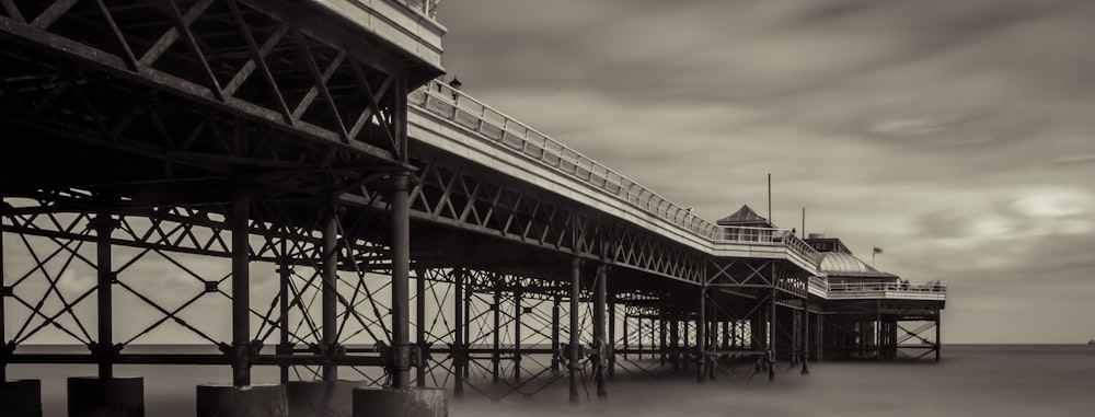 grayscale photography of bridge leading to building