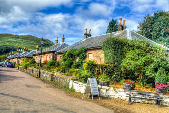 brown and gray concrete house near green trees under blue sky during daytime