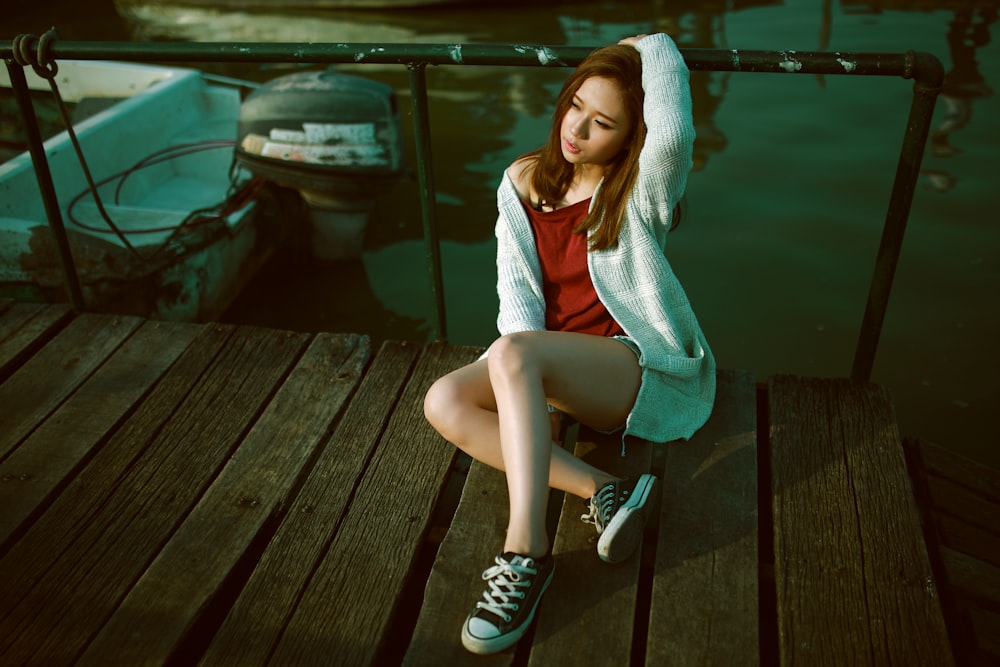 photography of woman holding bridge balustrade over body of water