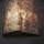An open book appears to be engulfed in swirling flames, with sparks and smoke surrounding it. The intense fiery effect creates a dramatic and surreal scene, suggesting destruction or transformation.