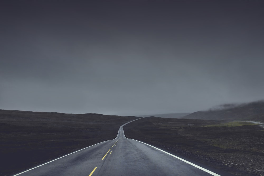 photography of road under cloudy sky