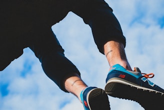Close-up of a runner's feet hitting the pavement with vibrant orange and blue gear.