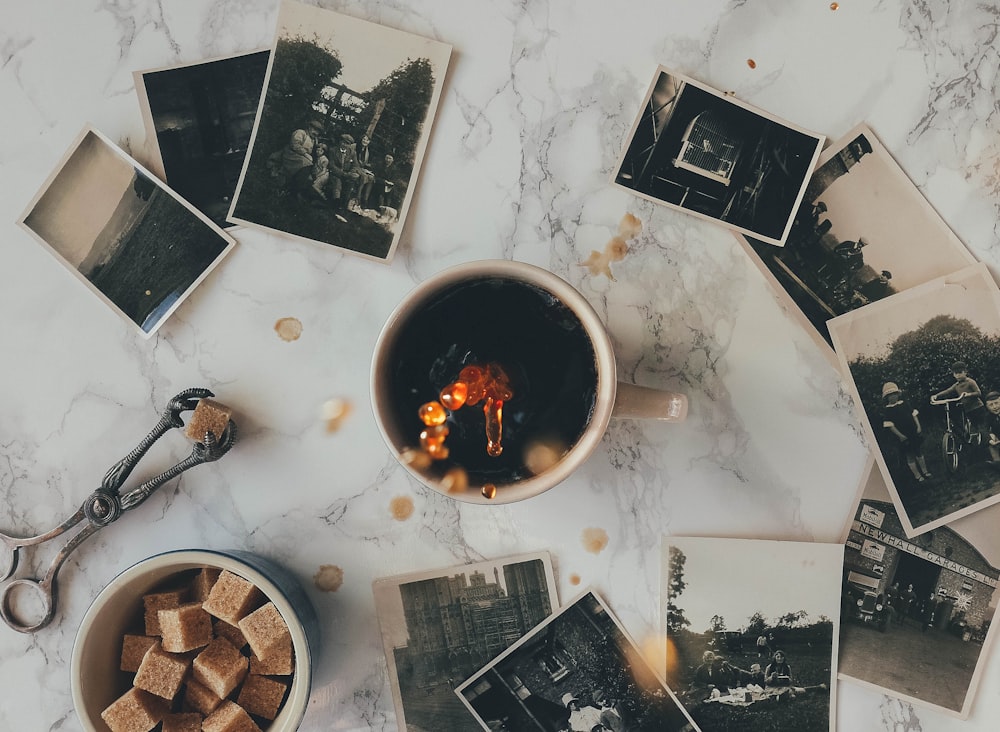 assorted grayscale photos near white ceramic mug