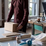 person holding cardboard box on table