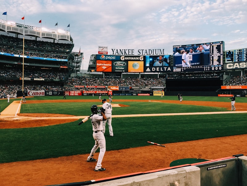 baseball stadium, baseball players, scoreboard, bleachers, baseball game action, pitcher throwing