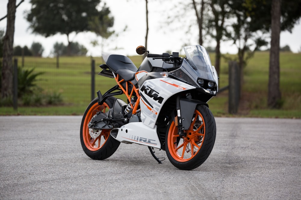 fotografia de foco seletivo da moto esportiva KTM branca e laranja