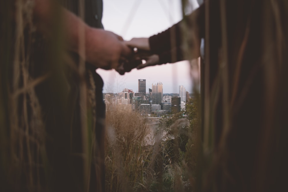 couple holding hands in a distance of city