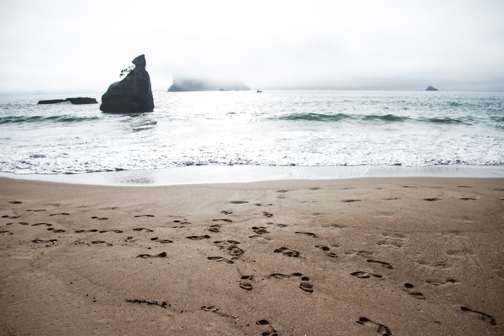 Strandsand mit Fußabdrücken während des Tages
