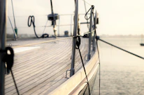 Close-up of a yacht's polished deck with turquoise sea in the background.