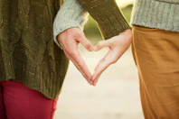 person forming heart shape with their hands