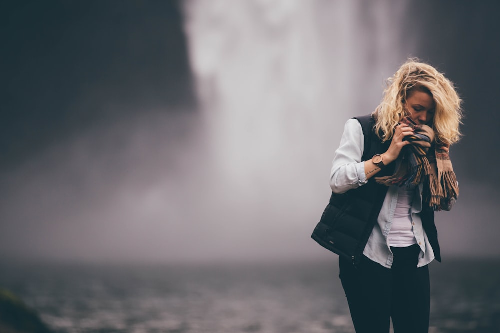 woman standing in front of waterfall