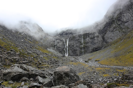 gray rock mountain during daytime in Homer Tunnel New Zealand