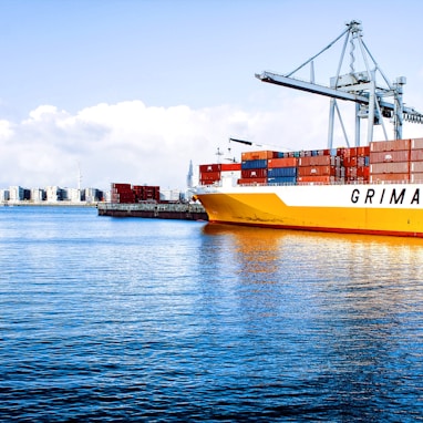 white and orange cargo ship with metal lifting equipment