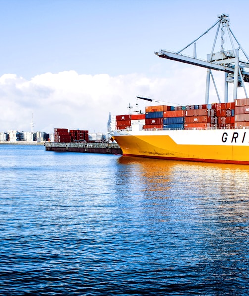 white and orange cargo ship with metal lifting equipment