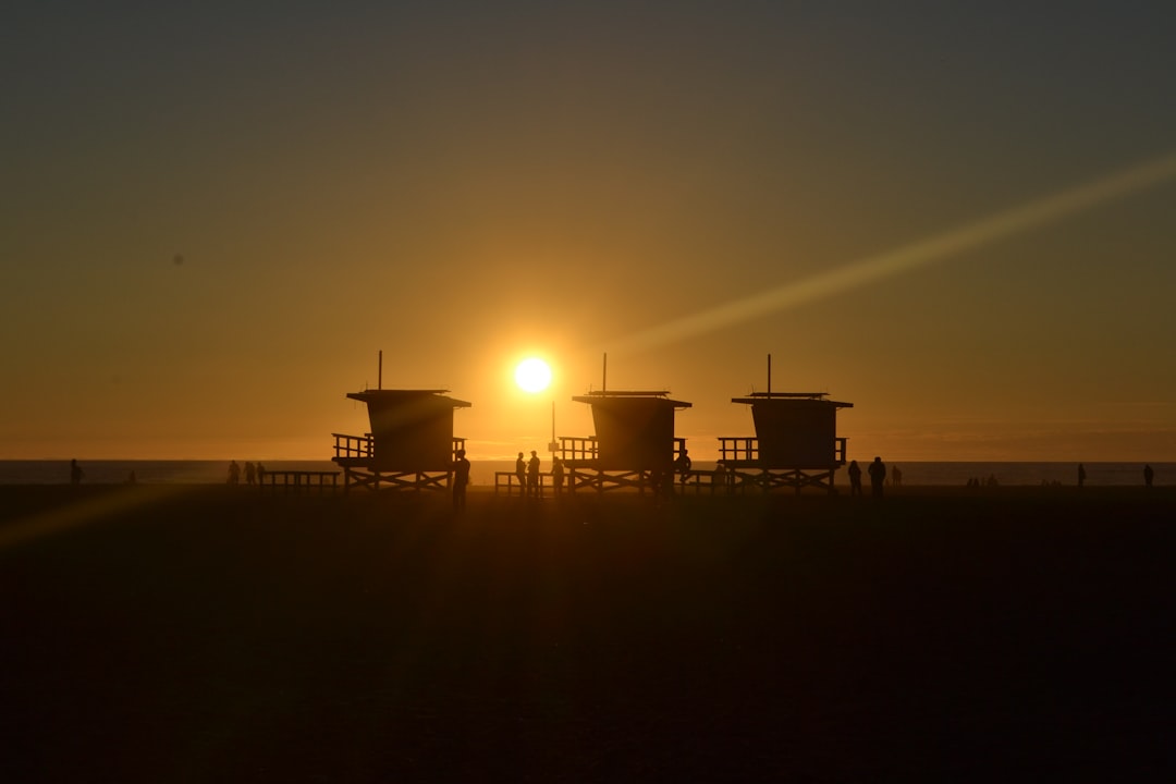 silhouette of three cottages on the beach