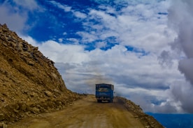 A sturdy cargo truck driving along a rural road in Chiloé under a cloudy sky
