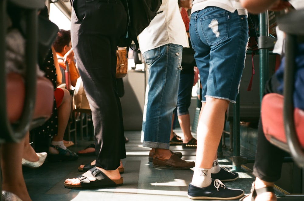 grupo de pessoas sentadas e em pé dentro do veículo