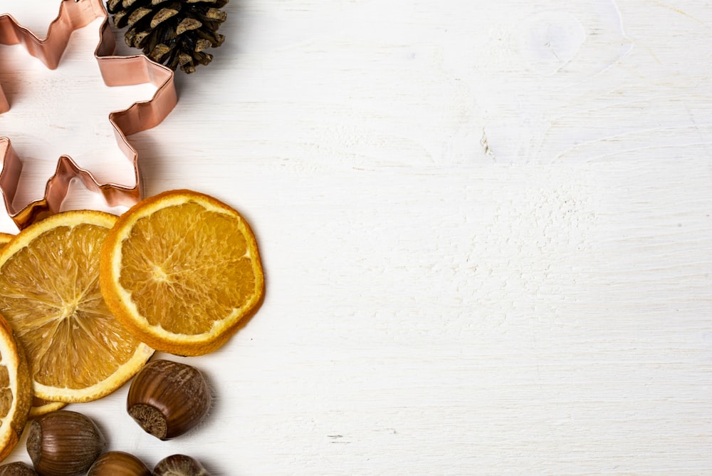 in Scheiben geschnittene orangefarbene Früchte auf weißer Oberfläche