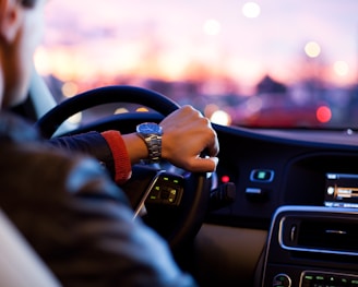 man driving a car wearing wrist watch