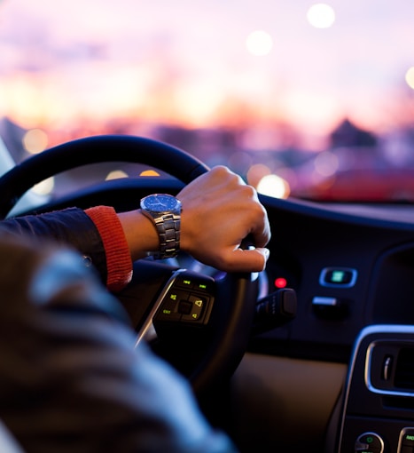 man driving a car wearing wrist watch