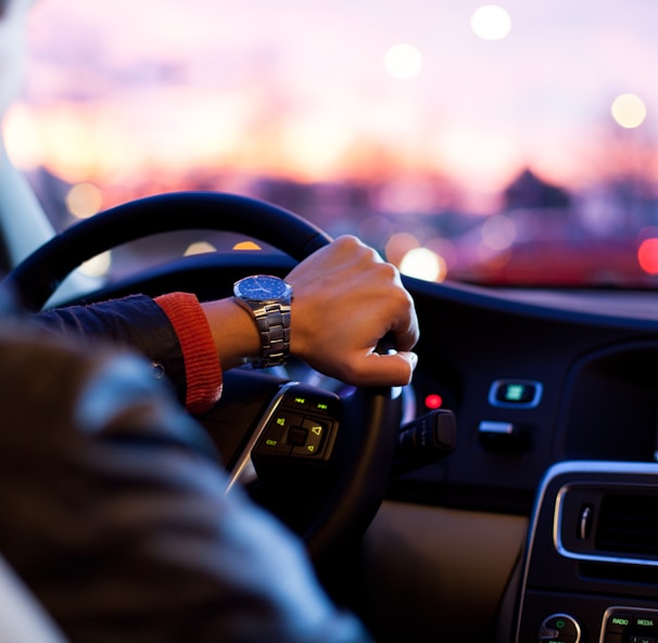 man driving a car wearing wrist watch