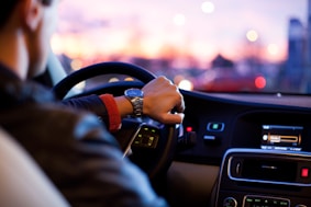man driving a car wearing wrist watch