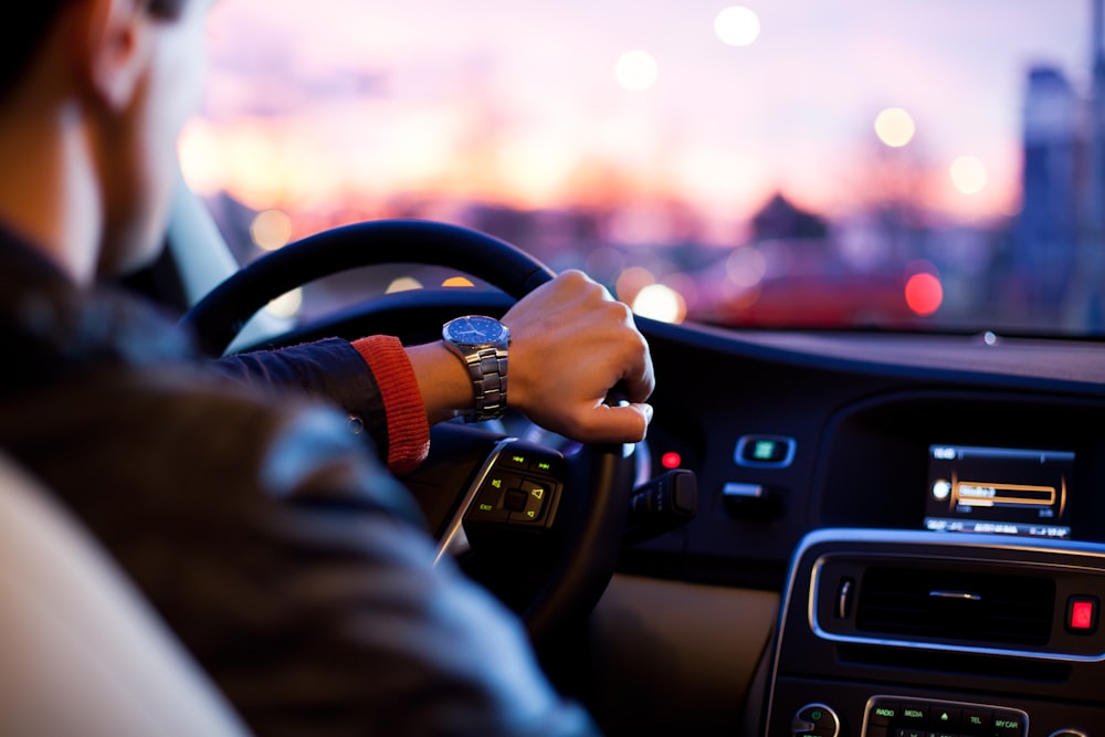 uomo che guida un'auto che indossa un orologio da polso