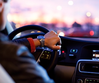 man driving a car wearing wrist watch