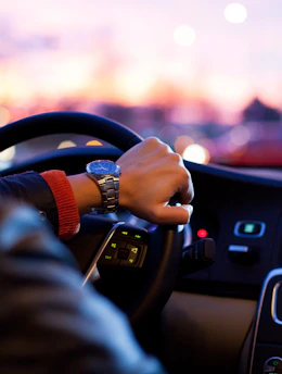 man driving a car wearing wrist watch