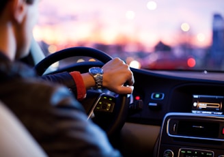 man driving a car wearing wrist watch