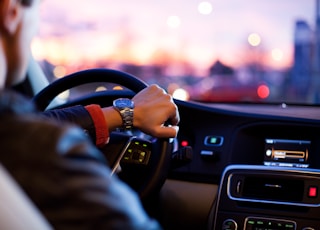 man driving a car wearing wrist watch