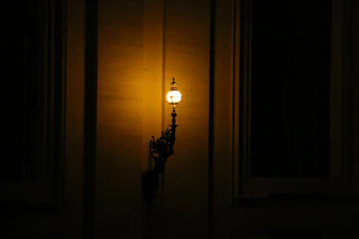 A stairway wall lamp with warm light highlighting textured walls.