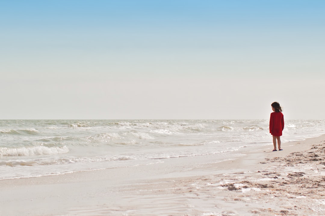 girl standing on seashore during daytime