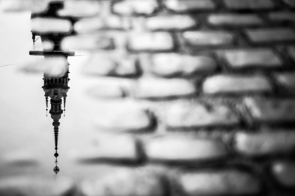 a reflection of a clock tower in a puddle of water