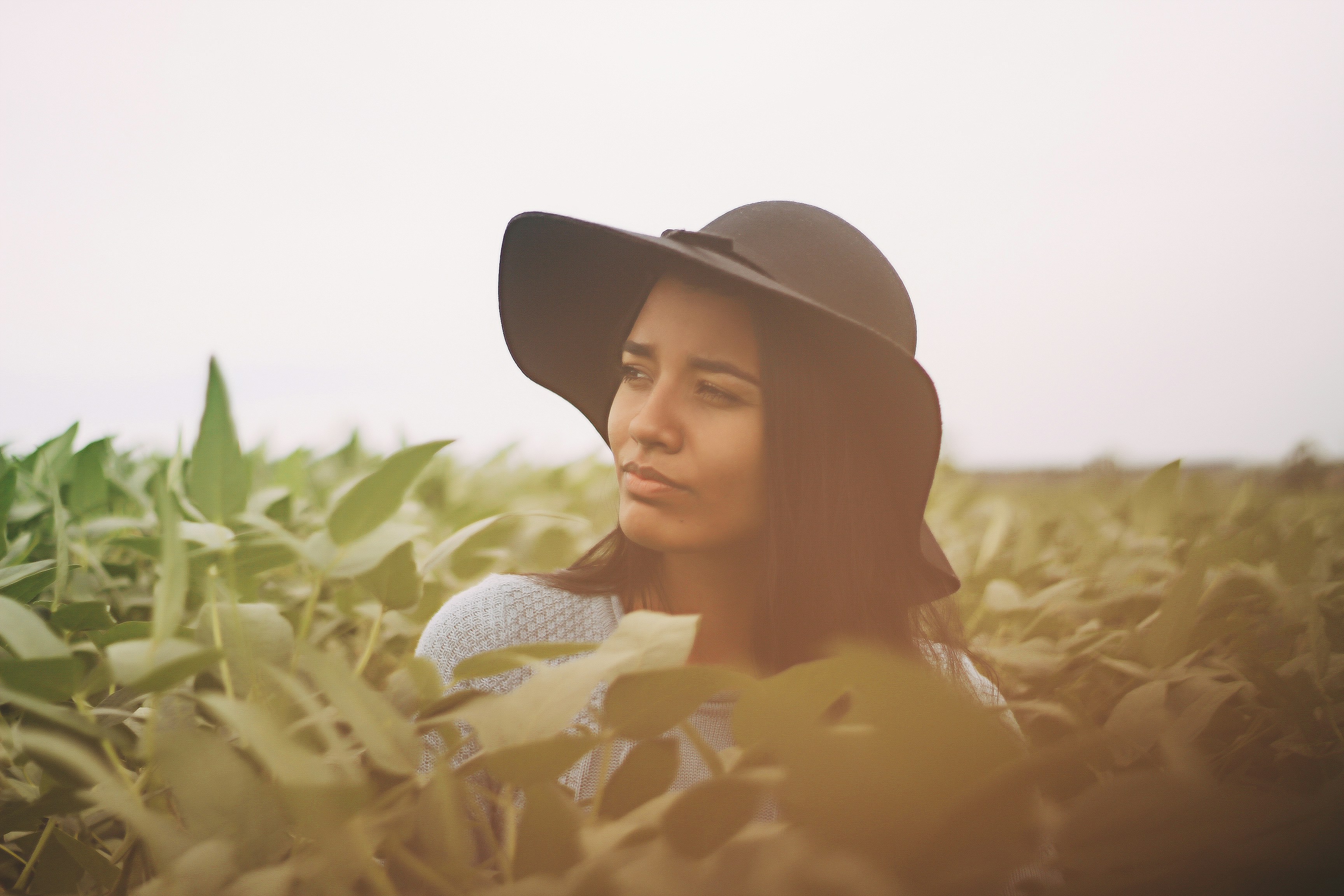photo of a woman taking a photo in the middle of green leaves