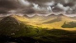 photography of green mountain under sky