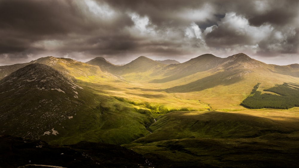 photography of green mountain under sky