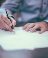 man writing on paper