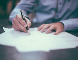 man writing on paper