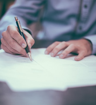 man writing on paper