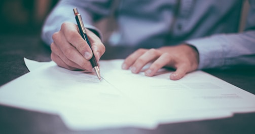 man writing on paper