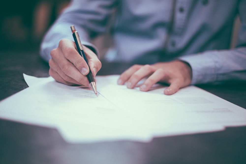 man writing on paper