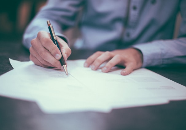 man writing on paper