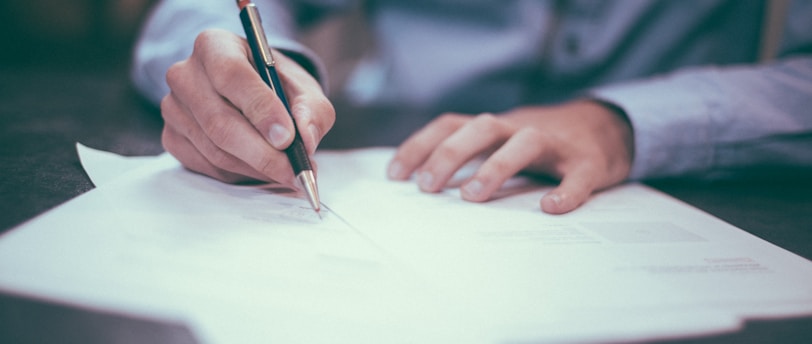 man writing on paper