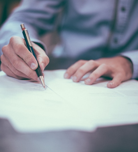 man writing on paper