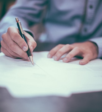 man writing on paper