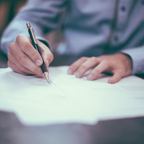 man writing on paper