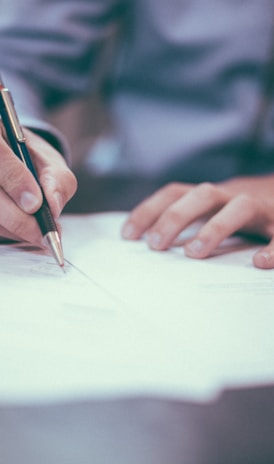 man writing on paper